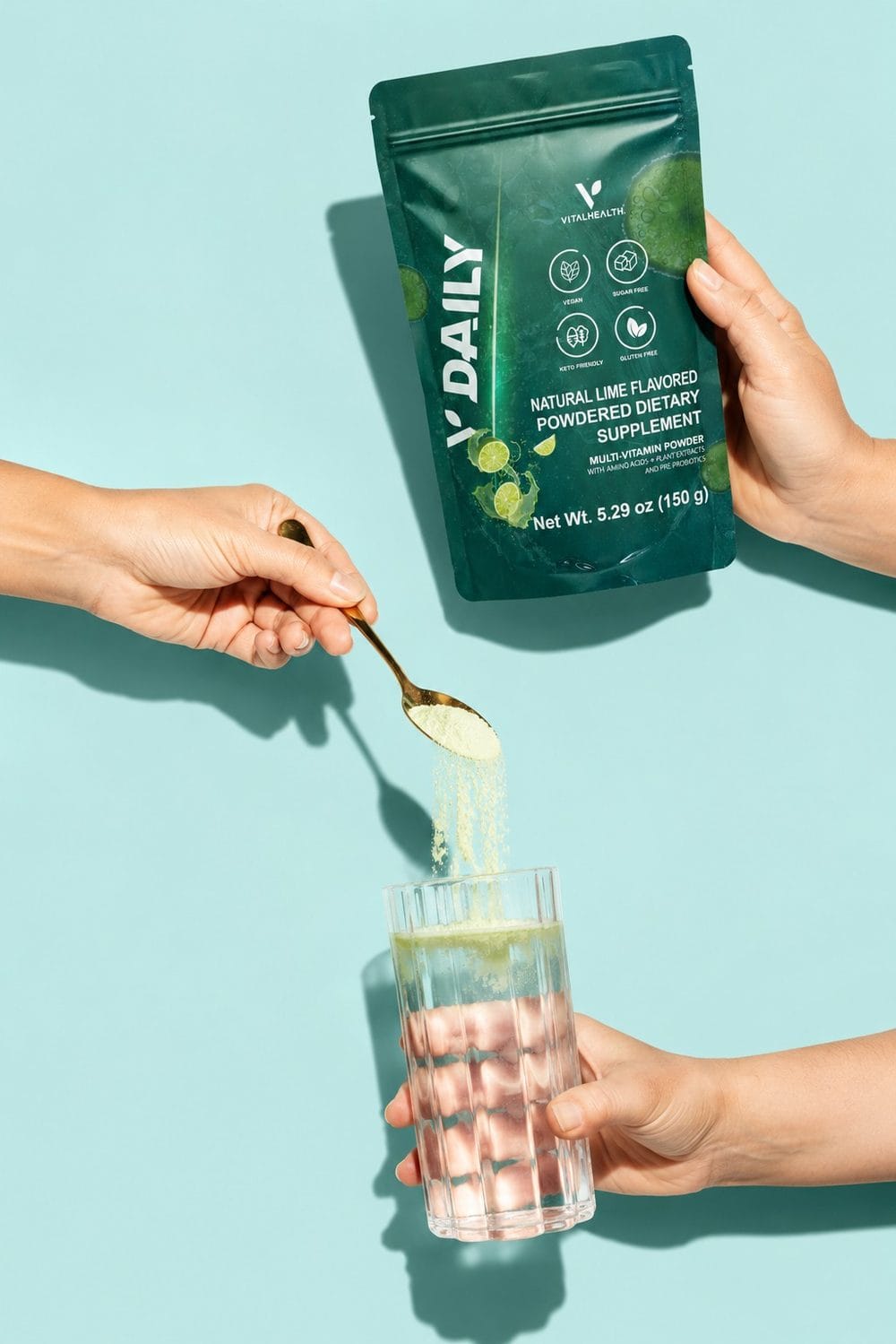 Scooping VitalHealth V-Daily lime flavored multivitamin powder into a glass of water